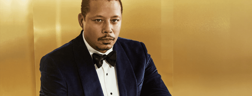 Man in blue suit against gold background.